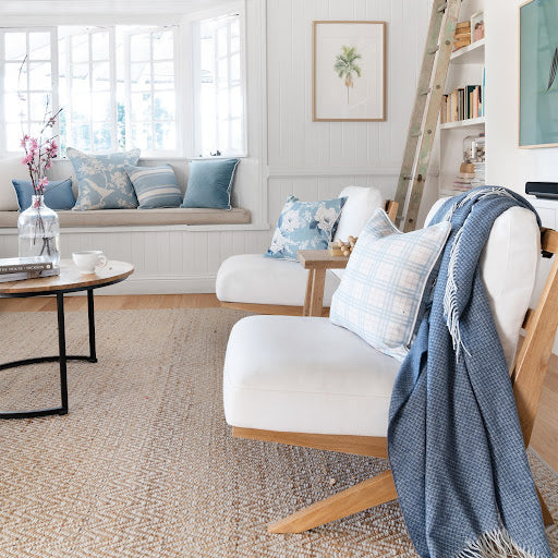 Designer coastal lounge with plaid lumbar cushion, blue throw and curated cushion cover set.